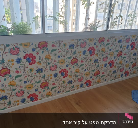 טפט פרחוני צבעוני על קיר לבן בחדר מואר